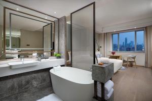 a bathroom with a tub and a large mirror at Crowne Plaza Shanghai Nanjing Road by IHG in Shanghai