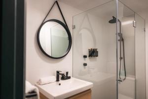 y baño con lavabo y espejo. en The Blue Hotel Bondi en Sídney