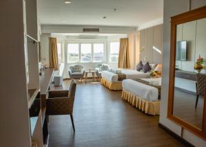 a hotel room with two beds and a living room at Siamgrand Hotel in Udon Thani