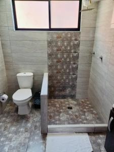 een badkamer met een toilet en een douche met een raam bij Casa completa amoblada Paipa con tres alcobas in Paipa