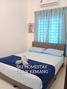 a bedroom with a bed with a blue curtain at Srz Homestay Teluk Kemang PD in Port Dickson