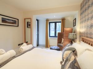 a bedroom with a bed and a chair and a window at Riverside Park 2 in Keswick