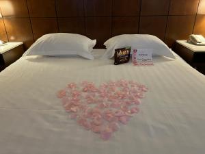 un cœur en pétales de rose sur un lit dans l'établissement LA Crystal Hotel -Los Angeles-Long Beach Area, à Carson