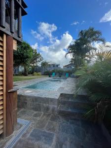 a swimming pool with stairs leading to a house at Rez-de-chaussée indépendant avec piscine in Sainte-Marie