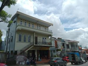 a building on a street with cars parked in front of it at Homestay Almanda Syariah Malino in Sungguminasa