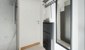 einen schwarzen Kühlschrank in einem Zimmer mit Spiegel in der Unterkunft Plater Residence Apartments in Warschau