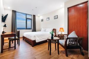 een slaapkamer met een bed, een tafel en stoelen bij Martin Ho Danang hotel & apartment in Da Nang +36 foto's