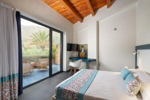 a bedroom with a bed and a sliding glass door at Magaggiari Hotel Resort in Cinisi