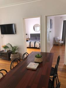 a living room with a table and a bedroom at St. Leonards Pier Beach House in Saint Leonards