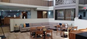 een restaurant met een bank en tafels en stoelen bij Holiday Inn - McAllen - Medical Center Area, an IHG Hotel in McAllen