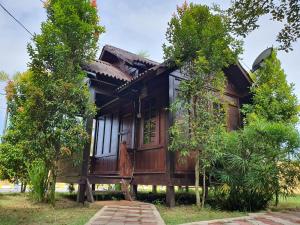 uma casa de madeira no meio das árvores em Alia Express Villa Temila Pasir Puteh em Pasir Puteh
