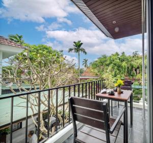 a balcony with a table and a view of the jungle at Em's House Hoi An Homestay in Hoi An
