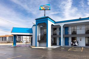 a hotel with a synergy inn sign in a parking lot at Shelby Inn in Memphis