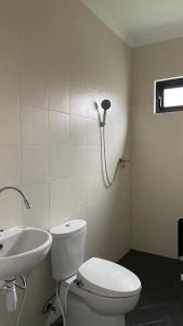 La salle de bains est pourvue de toilettes et d'un lavabo. dans l'établissement IM Merapi Homestay, à Ngaglik