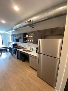 a kitchen with a stainless steel refrigerator and wooden floors at Luxury River-Front Handicap Accessible Studio Apt in Davenport