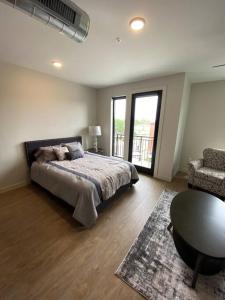 een slaapkamer met een bed, een tafel en een stoel bij Luxury River-Front Handicap Accessible Studio Apt in Davenport
