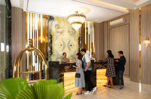 a group of people standing around a bar in a lobby at Dream of Aventus Hotel Kuta in Kuta