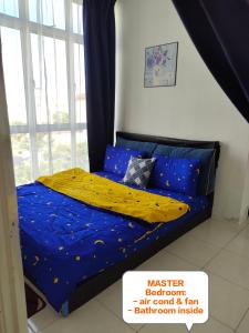 a bedroom with a bed with blue sheets and a window at UNIE HOMESTAY in Wakaf Che Yeh