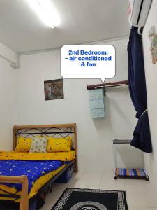 1 dormitorio con 1 cama y un cartel que lee aire acondicionado y ventilador en UNIE HOMESTAY, en Wakaf Che Yeh