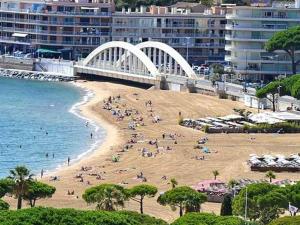 einen Strand mit Leuten darauf und einer Brücke in der Unterkunft Appartement Sainte-Maxime, 1 pièce, 4 personnes - FR-1-226-509 in Sainte-Maxime