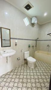 a bathroom with a toilet and a sink and a tub at Juan Beach Bungalow in Nusa Penida