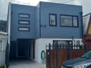 ein blaues Haus mit einem davor geparkt in der Unterkunft Cabañas y Departamentos Las Palmas, Temuco Depto 3 in Temuco
