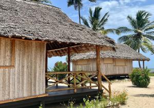 een hut met een rieten dak op een strand bij Barry's Beach Resort in Mkwaja