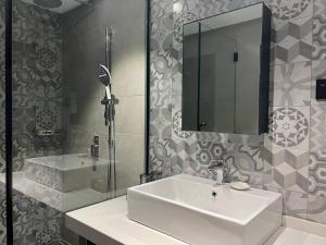 加央的住宿－ALL IN HOTEL，一间带水槽、镜子和淋浴的浴室