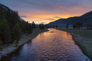 a view of a river at sunset with mountains at Crosswinds Inn in West Yellowstone