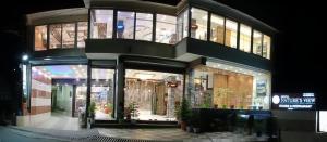 达兰萨拉Hotel Nature's View的夜晚的建筑物店面