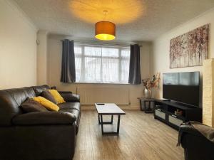 a living room with a couch and a flat screen tv at Nelly's Place hosted by AirOperate in Wealdstone