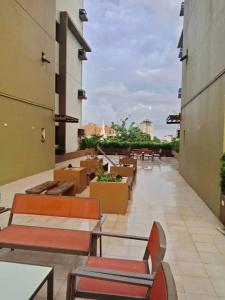 a balcony with chairs and tables on a building at Grand Residences Studio Unit - Walking Distance to IT Park in Cebu City