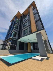 uma casa com uma piscina em frente em Increase hotel & residence em Samutprakarn