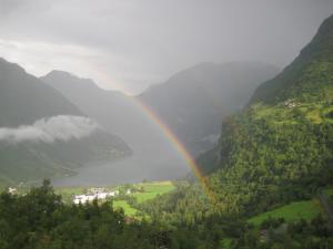a rainbow in the middle of a valley at Lunheim in Geiranger in Geiranger