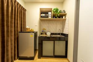 uma pequena cozinha com um lavatório e um frigorífico em Increase hotel & residence em Samutprakarn