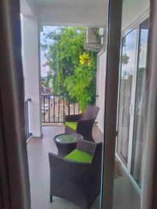 balcón con sillas, mesa y ventana en NINETY-NINE APARTMENTS en Kurunegala