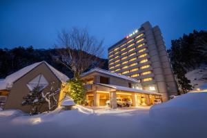 un hotel en la nieve frente a un edificio en Yumoto Kissho en Osaki