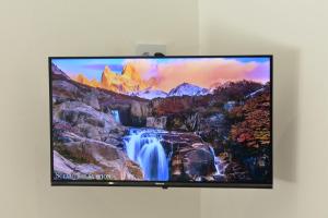 einen Flachbild-TV an einer Wand mit einem Wasserfall in der Unterkunft Langbeentjie Inn Two Point O in Kapstadt