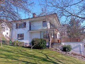 a large white house on a hill with a yard at Adenauer Cottage in Adenau