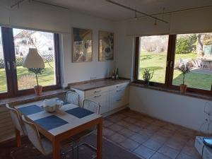 a kitchen with a table and a table and some windows at Adenauer Cottage in Adenau