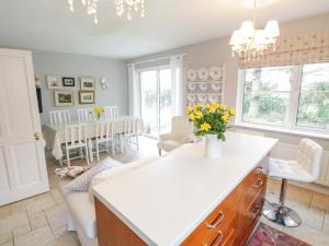 a kitchen and living room with a table and chairs at Springwood Cottage in Louisburgh