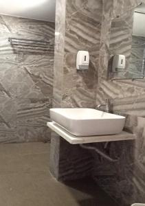 a bathroom with a sink and a mirror at The Grand Takshak Hotel in Mehsāna