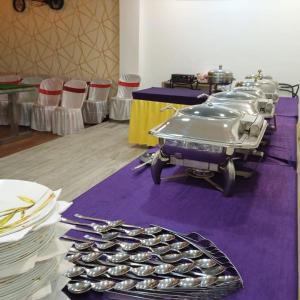 a table with plates and utensils on a purple table cloth at Empire Regency in Guwahati