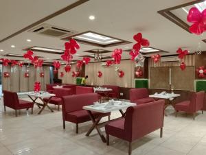 a restaurant with tables and red chairs and balloons at Hotel Madhuvan by TravelkartOnline in Dhanbād