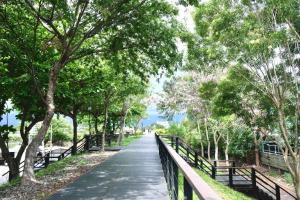 een loopbrug in een park met bomen en banken bij Taitung Railway Inn in Taitung