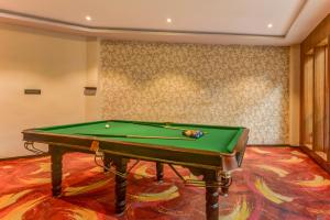 una mesa de billar verde en una habitación con pared en Summit Montana Suites & Spa, en Darjeeling
