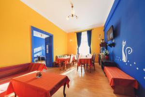 a restaurant with tables and chairs and a blue and yellow wall at Hostel Tara in Kraków
