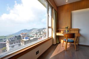 escritorio en una habitación con ventana grande en Summit Montana Suites & Spa, en Darjeeling