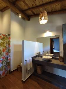 baño con lavabo y espejo grande en Casablue Baiana, en Porto Seguro