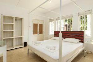1 dormitorio con 1 cama blanca con dosel en Lost & Found - Kandy, en Kandy